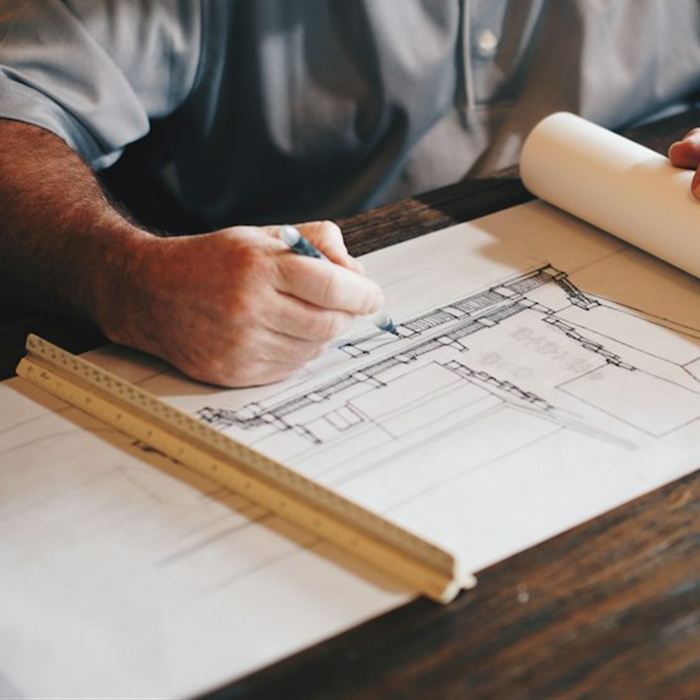 Un architecte dessine des plans avec une règle