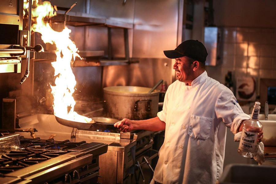 Un cuisinier aux fourneaux dans la cuisine d’un restaurant